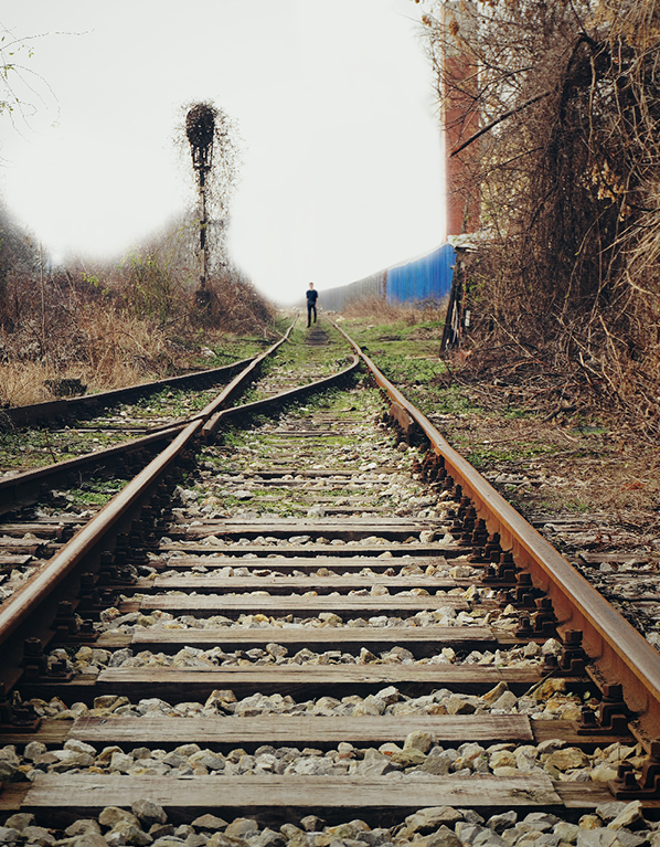 Photo montrant des rails de chemins de fer et un homme au loin